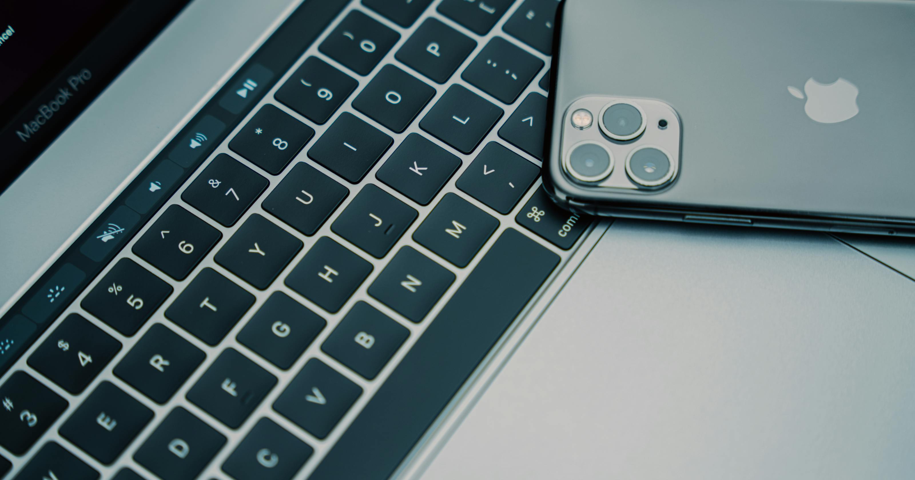iPhone and MacBook workspace representing remote Xcode builds for Windows developers