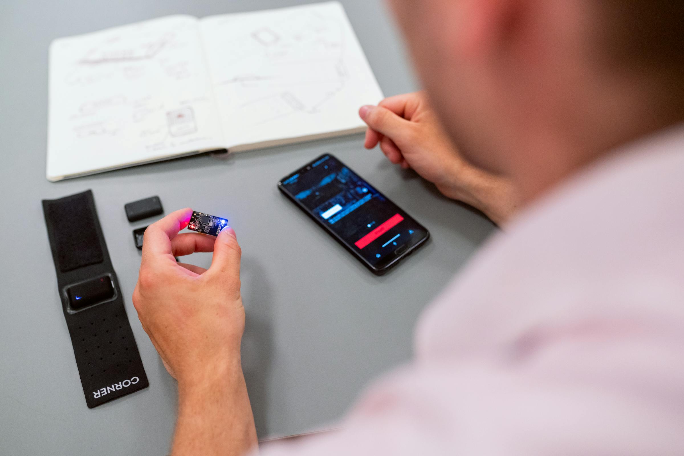 Développeur utilisant un smartphone et un MacBook pour illustrer un workflow iOS distant depuis Windows